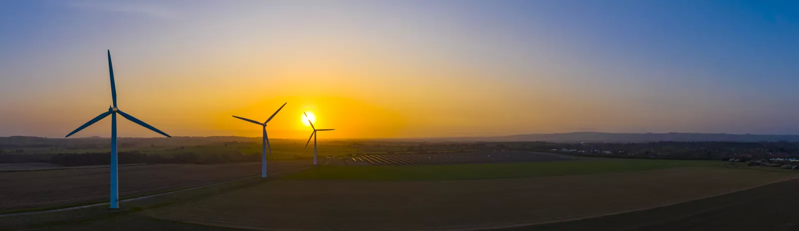 Dre Windkraftanlagen mit Sonnenuntergang