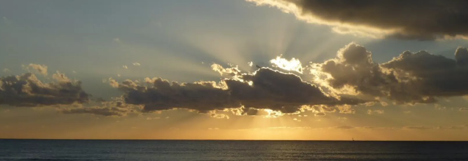 Foto Sonne hinter Wolke über dem Meer