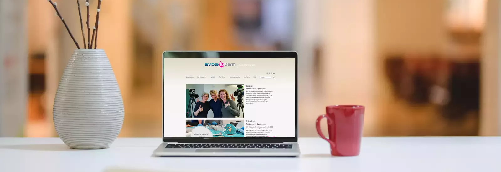 Symbol-Foto Schreibtisch mit Notebook vor unscharfem Hintergrund