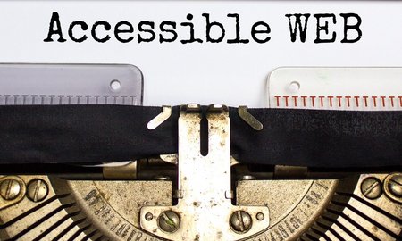 Alte mechanische Schreibmaschine. Auf dem eingespanntem Papier steht getippt "Accessible Web"